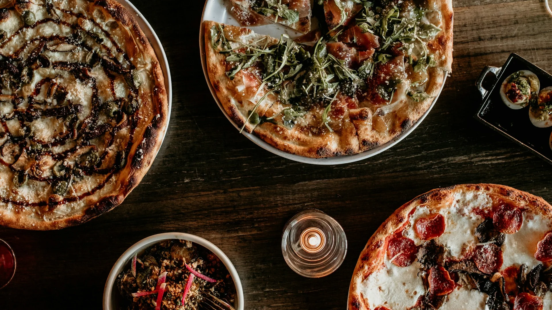 Pizzas and small plates shared around the table